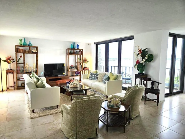 a living room with furniture a flat screen tv and a large window