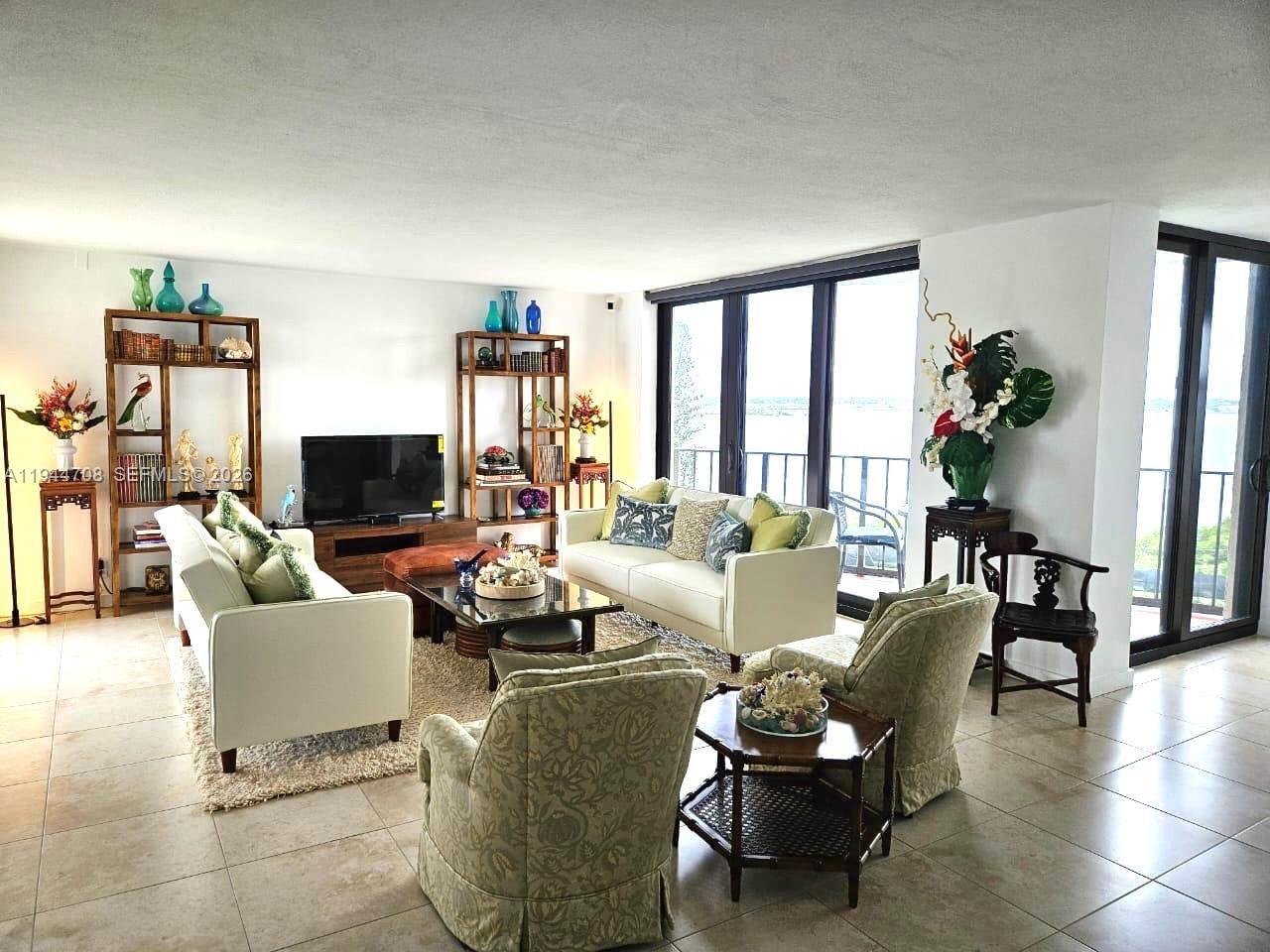 5420 North Ocean Drive, Unit 706 Singer Island, FL 33404 - Photo 3 of 41 a living room with furniture a flat screen tv and a large window