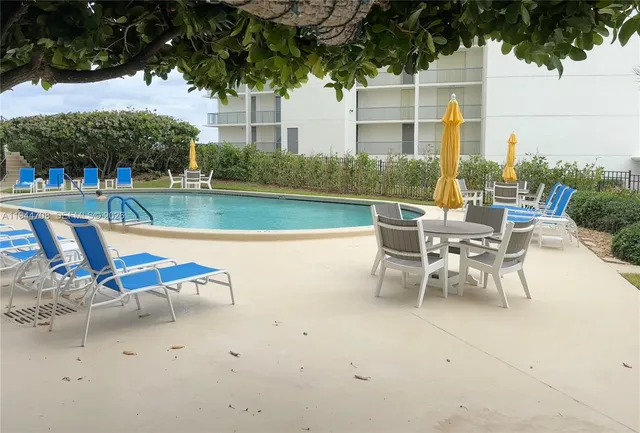 a view of a patio with chairs and potted plants