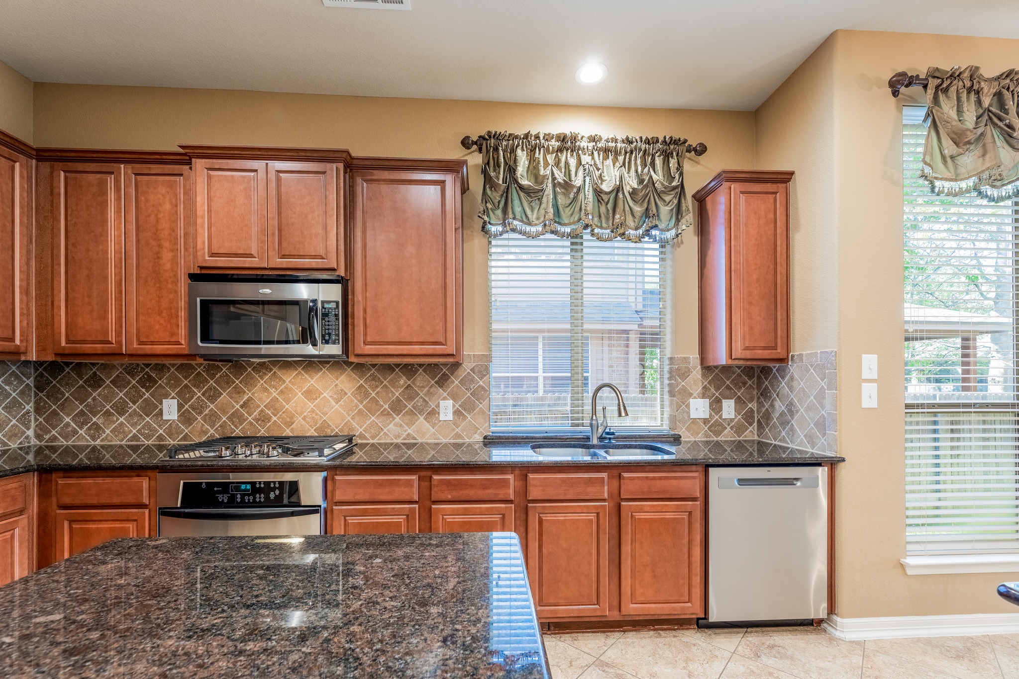 20804 Windmill Ridge Street Pflugerville, TX 78660 - Photo 12 of 40 Desirable stainless steel appliances include a built-in range with electric oven and gas cooktop, plus a microwave and dishwasher.