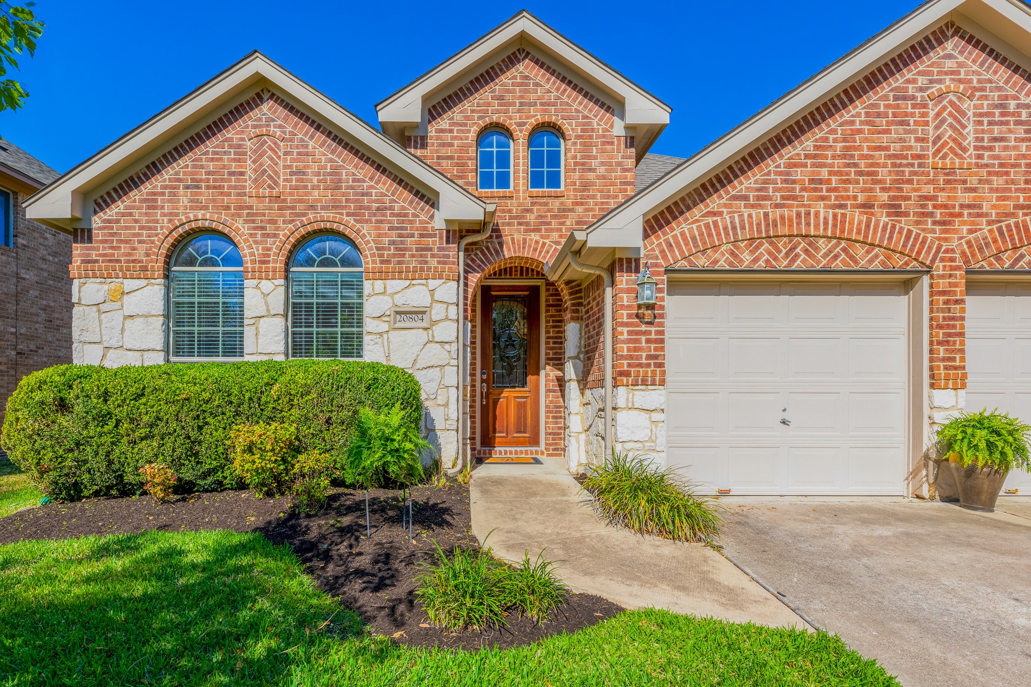 20804 Windmill Ridge Street Pflugerville, TX 78660 - Photo 6 of 40 Polished curb appeal with striking masonry and lush, well maintained landscaping, plus a 3-Car garage!