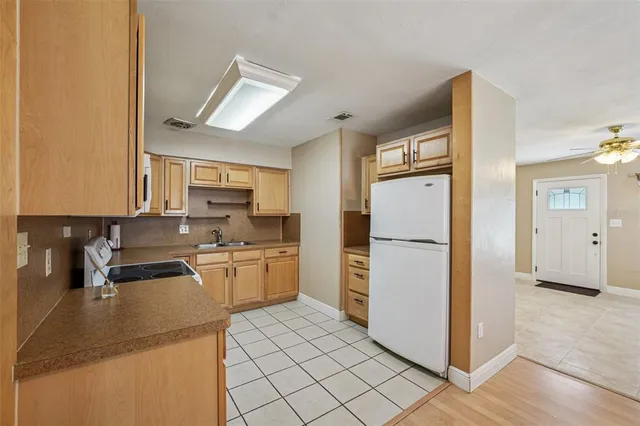 a kitchen with a refrigerator a stove top oven and cabinets