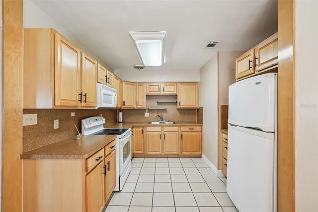 a kitchen with a refrigerator a stove top oven and cabinets