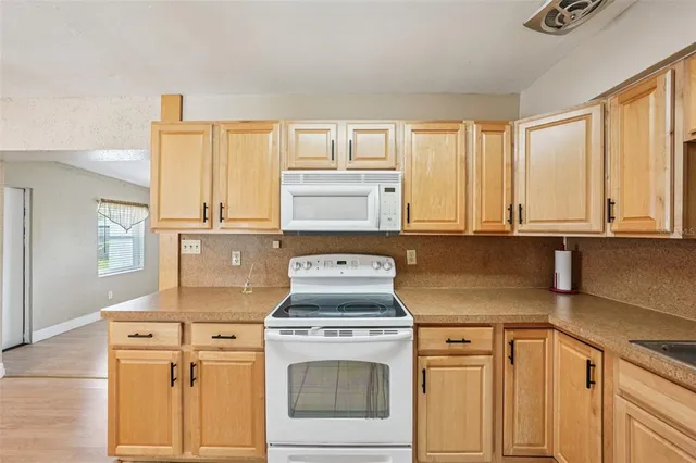 a kitchen with granite countertop white cabinets and white appliances