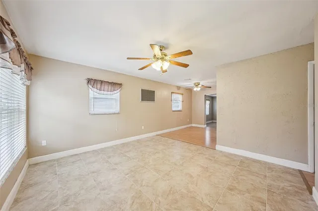 an empty room with a window and a ceiling fan