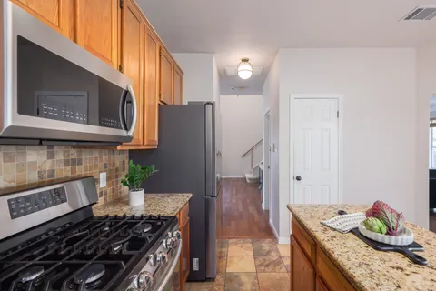a kitchen with stainless steel appliances granite countertop a stove and a microwave