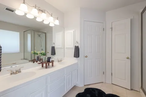 a bathroom with double vanity sink and a mirror