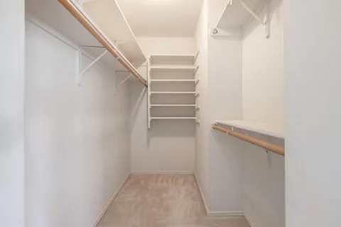 a view of walk in closet with empty racks