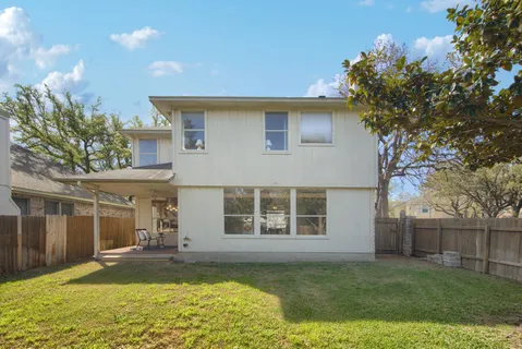 a view of a house with backyard and sitting area