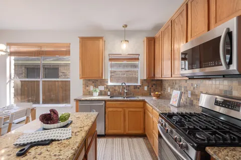 a kitchen with stainless steel appliances granite countertop a stove and a microwave