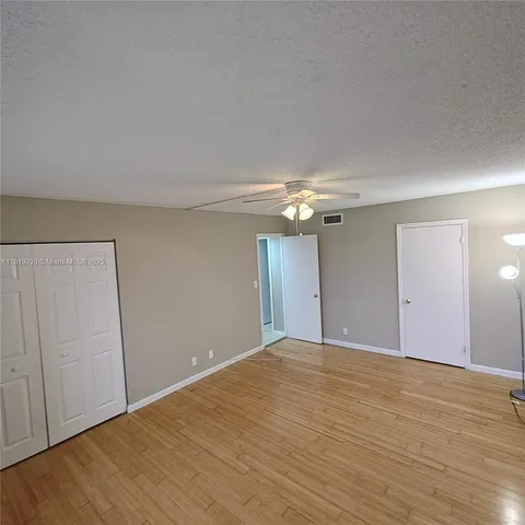 a view of a room with wooden floor and windows