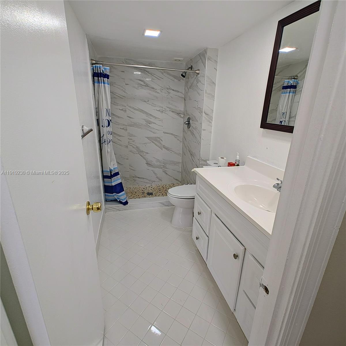 7051 Environ Boulevard, Unit 433 Lauderhill, FL 33319 - Photo 25 of 36 a bathroom with a double vanity sink toilet and shower