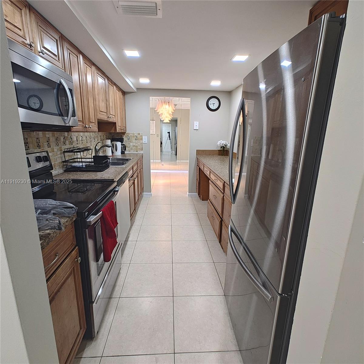 7051 Environ Boulevard, Unit 433 Lauderhill, FL 33319 - Photo 27 of 36 a kitchen with stainless steel appliances granite countertop a refrigerator a stove a sink and dishwasher