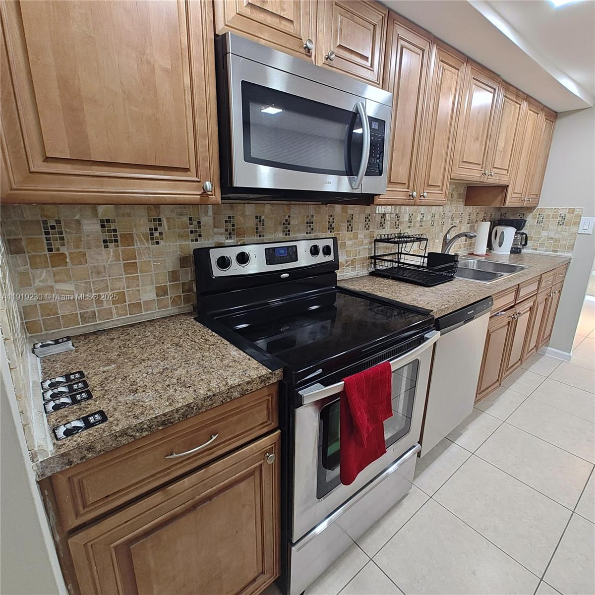 7051 Environ Boulevard, Unit 433 Lauderhill, FL 33319 - Photo 28 of 36 a kitchen with stainless steel appliances granite countertop a stove a sink and a microwave