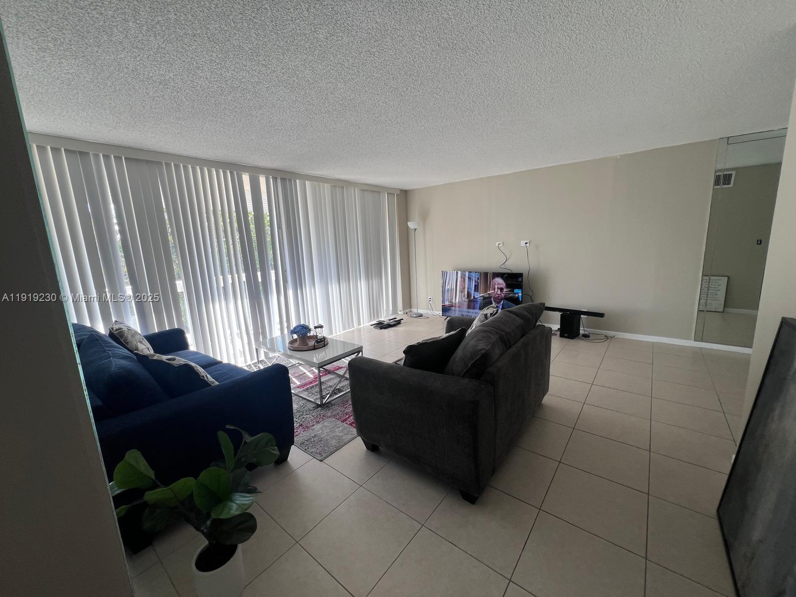 7051 Environ Boulevard, Unit 433 Lauderhill, FL 33319 - Photo 6 of 36 a living room with furniture and a window