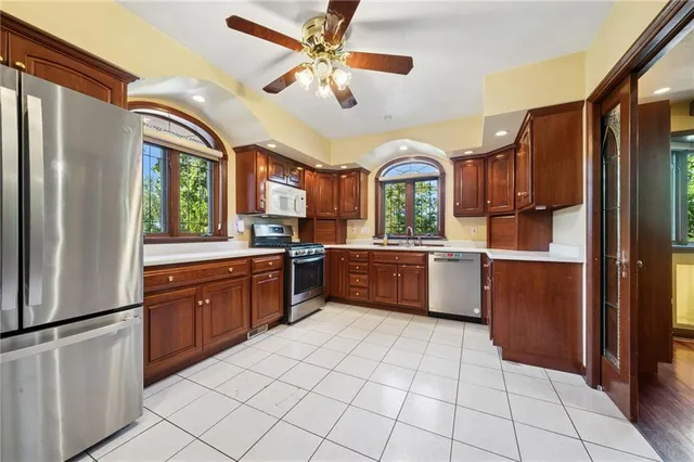a kitchen with stainless steel appliances granite countertop a refrigerator a sink a stove top oven and a refrigerator