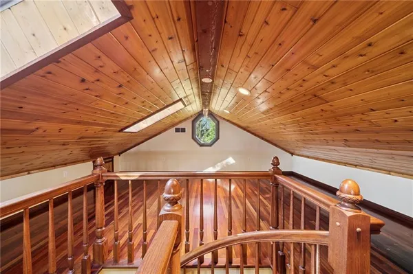 an empty room with wooden floor a ceiling fan and windows