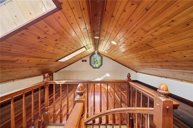 an empty room with wooden floor a ceiling fan and windows