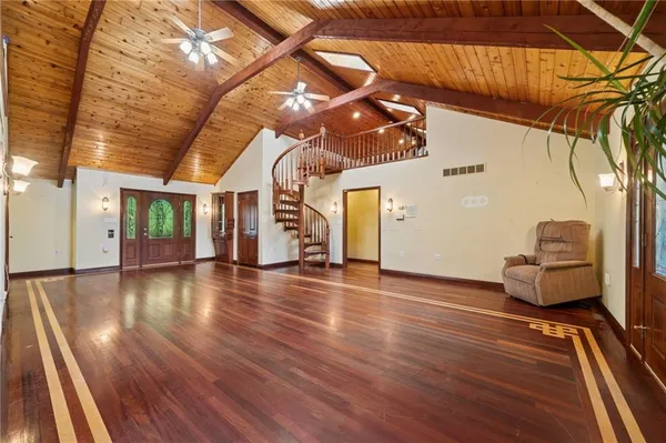 a view of a livingroom with wooden floor and furniture