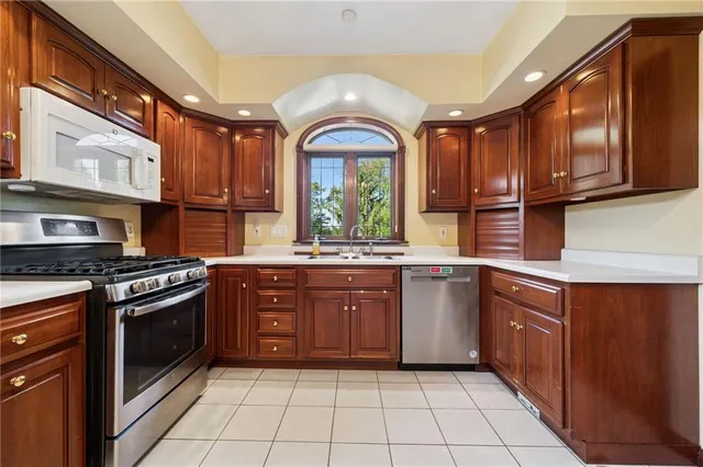 a kitchen with stainless steel appliances granite countertop a stove a sink and a microwave