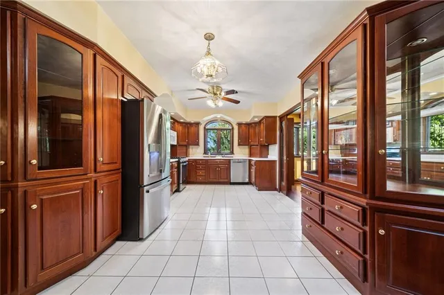 a large kitchen with stainless steel appliances granite countertop a refrigerator and a view of living room