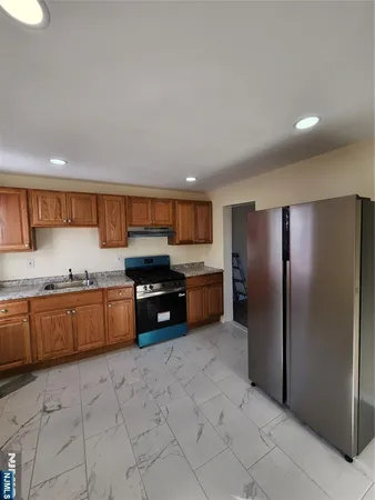 a kitchen with stainless steel appliances granite countertop a refrigerator and a sink