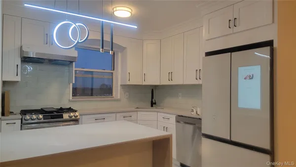 a kitchen with stainless steel appliances granite countertop a sink a stove and a refrigerator