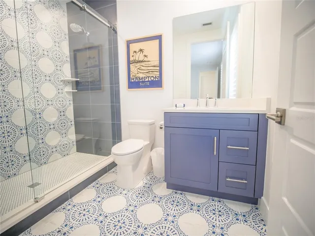 a large bedroom with a bed and wooden floor