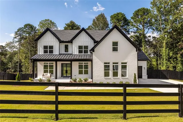 a front view of house with yard and trees in the background
