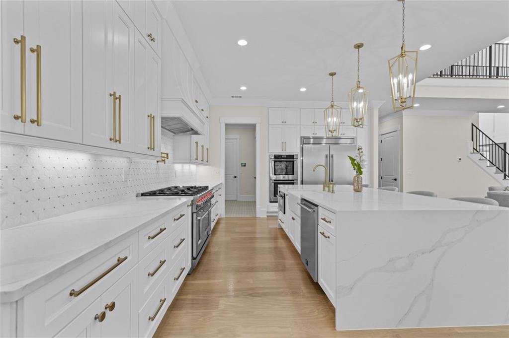 5 Olevia Street Winder, GA 30680 - Photo 36 of 106 a large kitchen with stainless steel appliances kitchen island granite countertop a large counter top a sink stainless steel appliances and cabinets