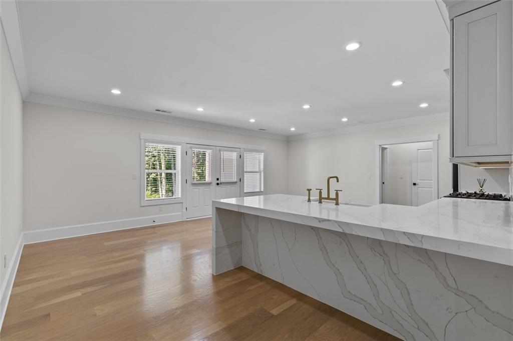 5 Olevia Street Winder, GA 30680 - Photo 63 of 106 a large kitchen with stainless steel appliances a large counter top a sink and a wooden floor