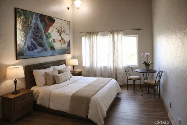 a bedroom with a bed and a painting on the wall