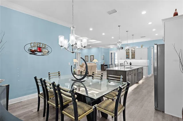 a kitchen with stainless steel appliances kitchen island granite countertop a table chairs microwave and white cabinets