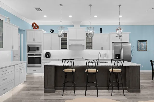 a kitchen with stainless steel appliances granite countertop lots of counter top space and furniture