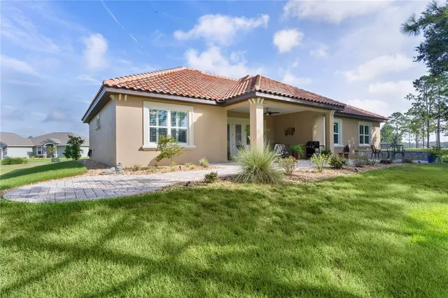 a view of a house with a yard and tree s