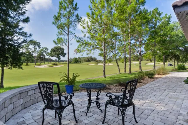 a view of a chairs and table in the patio with a lake view