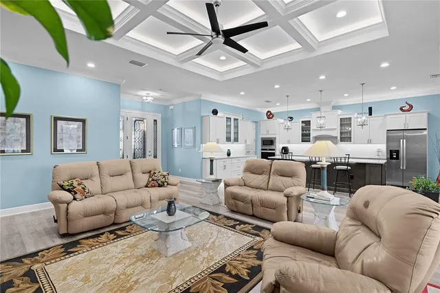 a living room with furniture kitchen view and a chandelier