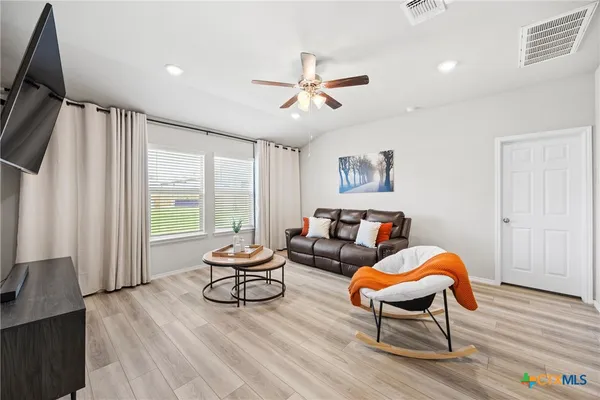 a living room with furniture and a wooden floor