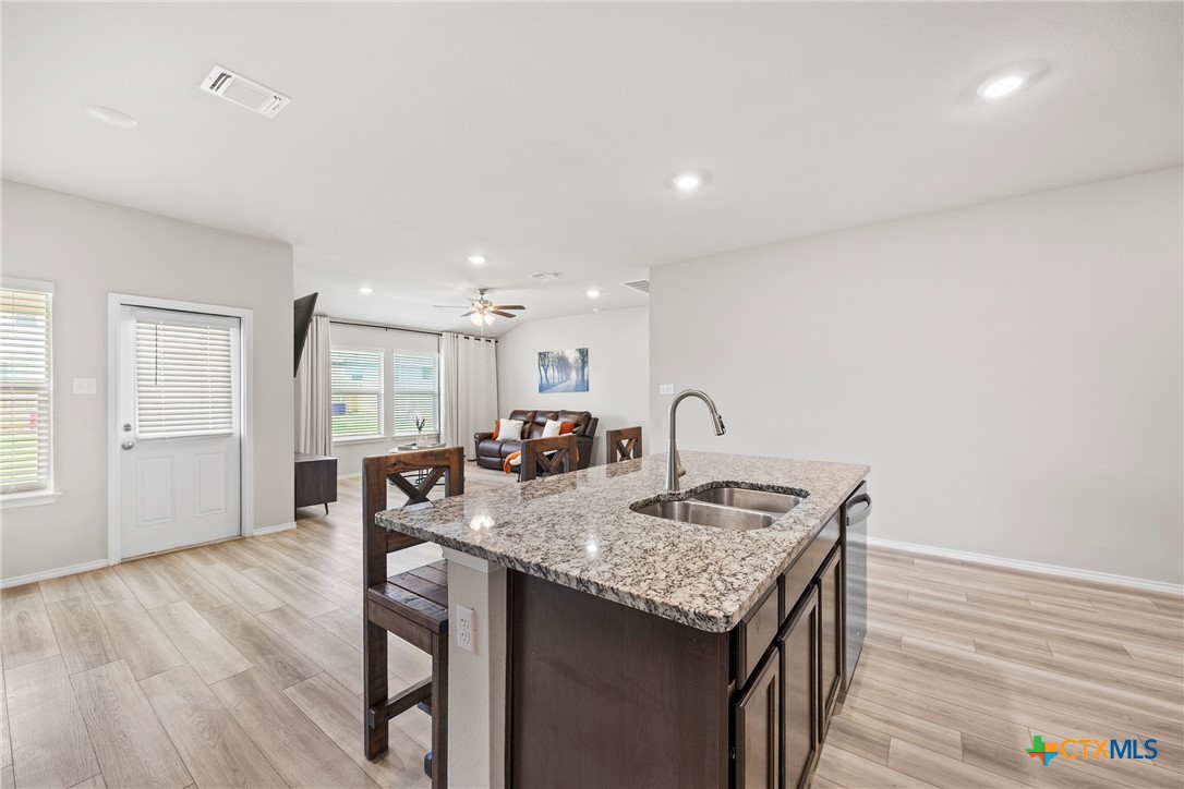 8903 Cantera Rdg Road Temple, TX 76502 - Photo 7 of 25 a view of kitchen island with granite countertop refrigerator stove dining table and chairs