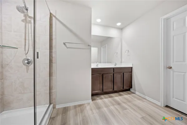 a bathroom with a shower sink and mirror