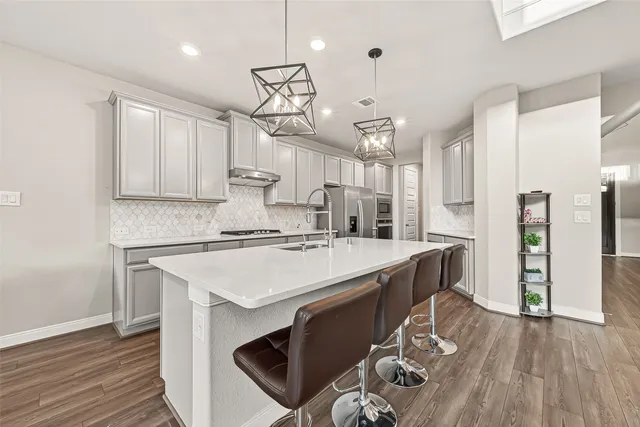 a kitchen with kitchen island a wooden floor and white appliances
