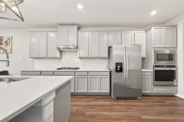 a kitchen with stainless steel appliances a refrigerator sink and cabinets