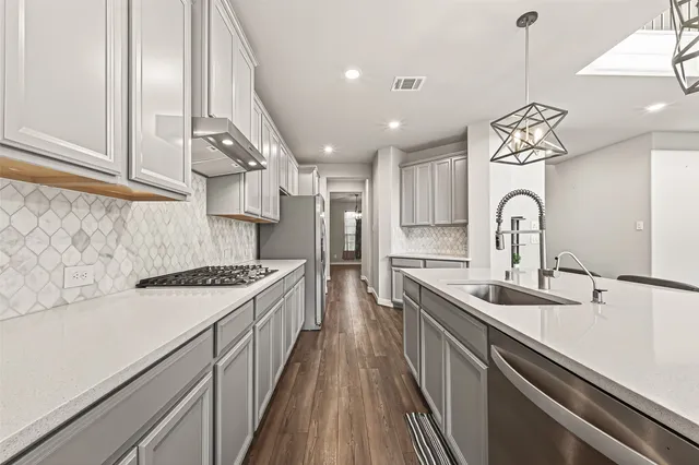 a kitchen with granite countertop a sink stainless steel appliances and cabinets