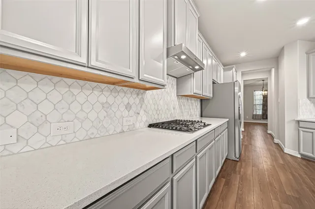 a kitchen with a stove and a white refrigerator