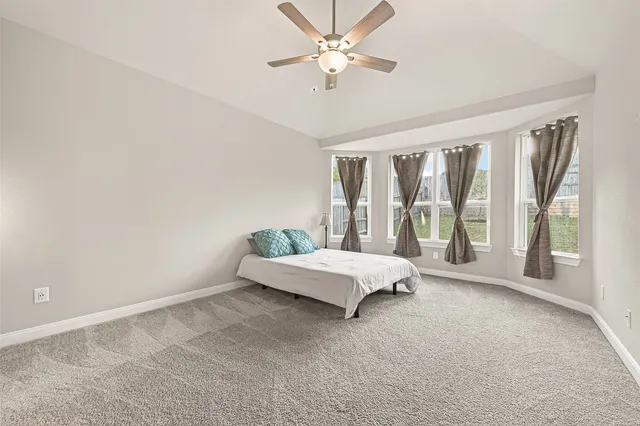 a spacious bedroom with a large bed and a large window with balcony view