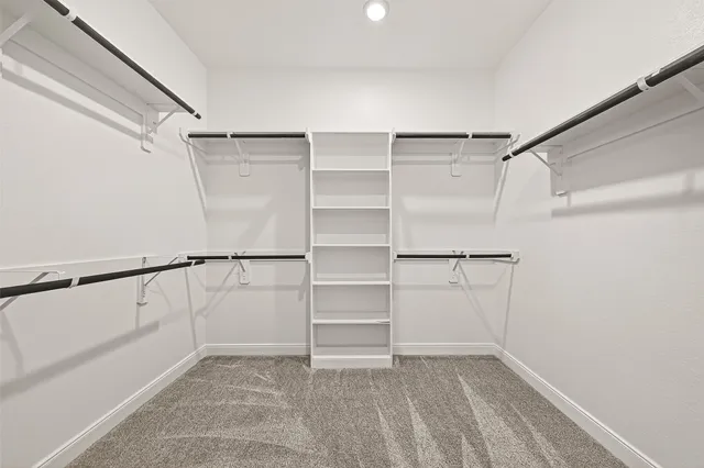 a view of walk in closet with empty racks