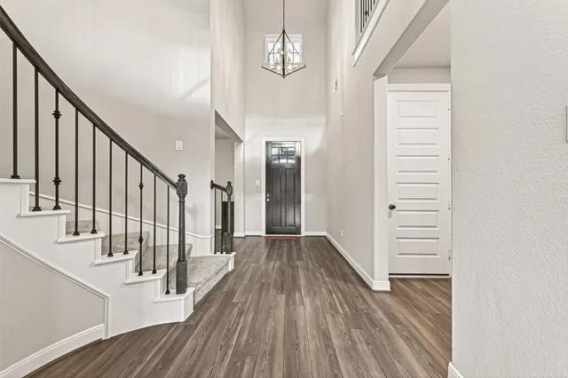 a view of a hallway with wooden floor and staircase