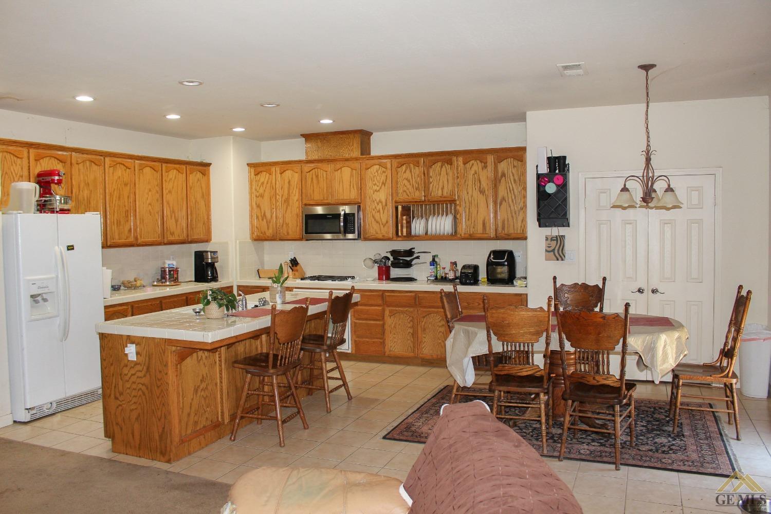 Undisclosed Address Bakersfield, CA 93311 - Photo 6 of 10 a kitchen with stainless steel appliances kitchen island granite countertop a table and chairs