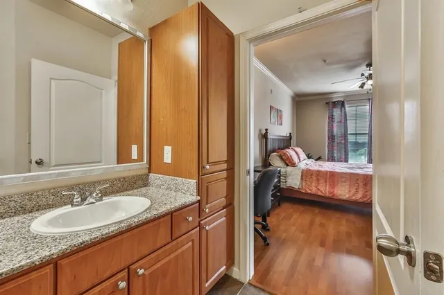 a en suite bathroom with a granite countertop sink and a mirror
