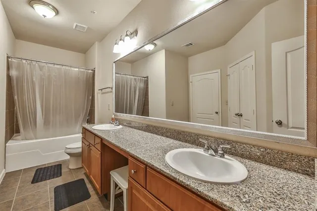 a bathroom with a granite countertop sink a mirror and a bathtub